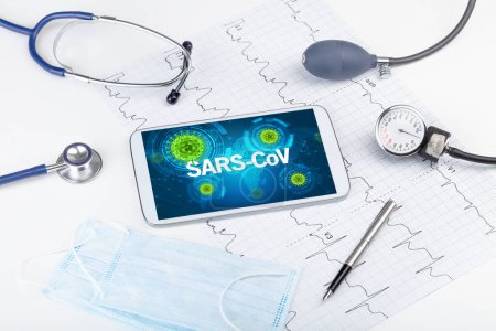 Foto de Vista de cerca de una tableta PC con inscripción SARS-CoV, concepto de microbiología - Imagen libre de derechos