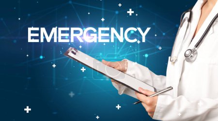 Photo for Doctor fills out medical record with EMERGENCY inscription, medical concept - Royalty Free Image