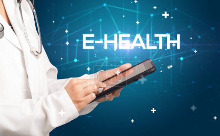 Photo for Doctor fills out medical record with E-HEALTH inscription, medical concept - Royalty Free Image