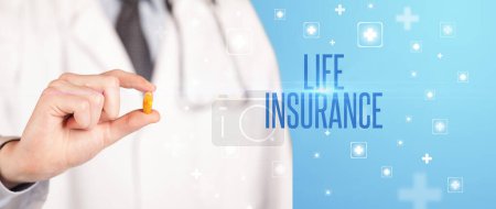 Photo for Close-up of a doctor giving a pill with LIFE INSURANCE inscription, medical concept - Royalty Free Image