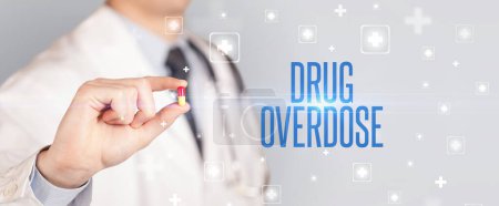 Téléchargez les photos : Gros plan d'un médecin qui donne une pilule avec inscription DRUG OVERDOSE, concept médical - en image libre de droit