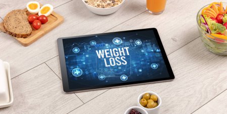 Foto de Concepto de pérdida de peso en la tableta PC con alimentos saludables alrededor, vista superior - Imagen libre de derechos