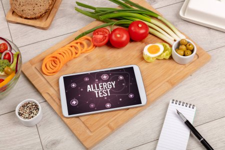 Téléchargez les photos : ESSAI D'ALLERGIE concept en tablette PC avec des aliments sains autour, vue du dessus - en image libre de droit