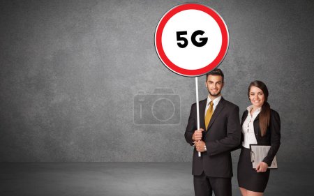 Téléchargez les photos : Jeune homme d'affaires holdig panneau de signalisation avec abréviation 5G, concept de solution technologique - en image libre de droit