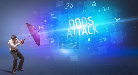 Téléchargez les photos : Homme d'affaires défendant avec parapluie contre la cyberattaque et l'inscription DDOS ATTACK, concept de sécurité en ligne - en image libre de droit