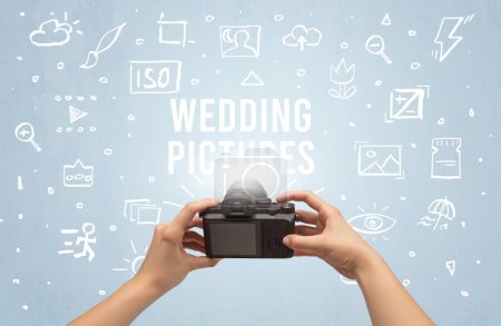 Photo for Hand taking picture with digital camera and WEDDING PICTURES inscription, camera settings concept - Royalty Free Image