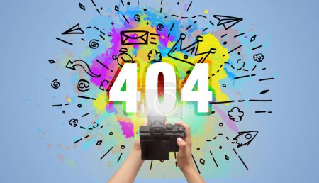 Foto de Primer plano de una cámara digital de mano con dibujo abstracto e inscripción 404 - Imagen libre de derechos