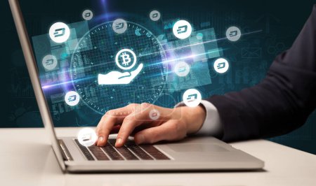 Photo for Business hand working in stock market with giving bitcoin icons coming out from laptop screen - Royalty Free Image