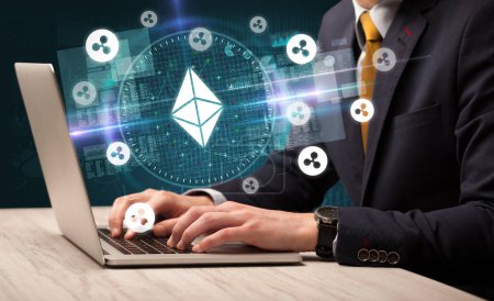 Photo for Business hand working in stock market with ethereum icons coming out from laptop screen - Royalty Free Image