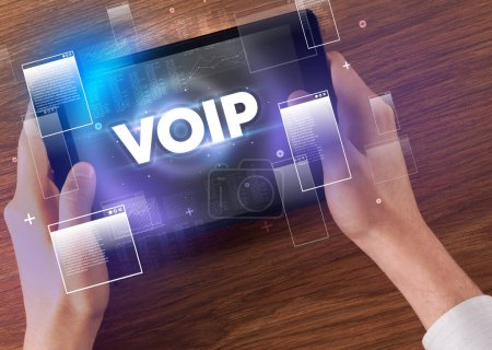 Foto de Primer plano de una tableta de mano con abreviatura VOIP, concepto de tecnología moderna - Imagen libre de derechos