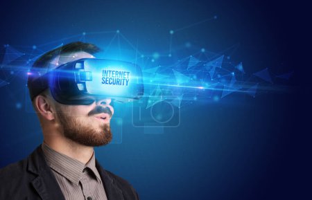 Foto de Hombre de negocios mirando a través de gafas de realidad virtual con inscripción INTERNET SECURITY, concepto de seguridad cibernética - Imagen libre de derechos