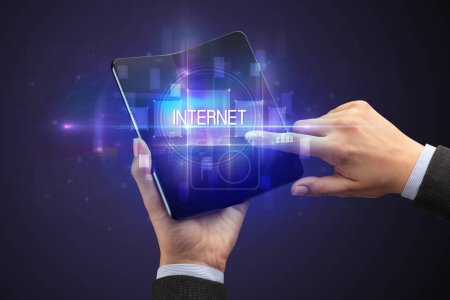 Foto de Empresario sosteniendo un smartphone plegable con inscripción INTERNET, concepto de nueva tecnología - Imagen libre de derechos