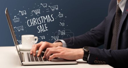 Téléchargez les photos : Homme d'affaires travaillant sur ordinateur portable avec inscription CHRISTMAS SALE, concept d'achat en ligne - en image libre de droit