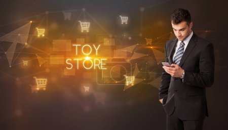 Photo for Businessman with shopping cart icons and TOY STORE inscription, online shopping concept - Royalty Free Image