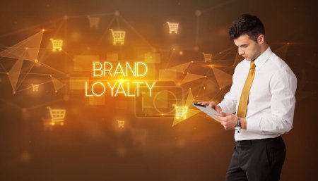 Photo for Businessman with shopping cart icons and BRAND LOYALTY inscription, online shopping concept - Royalty Free Image
