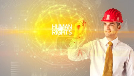 Foto de Hombre de negocios guapo con dibujo casco DERECHOS HUMANOS inscripción, concepto de construcción social - Imagen libre de derechos