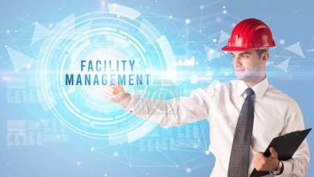 Photo for Handsome businessman with helmet drawing FACILITY MANAGEMENT inscription, contruction business concept - Royalty Free Image