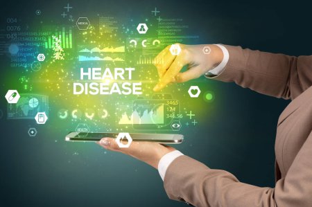 Téléchargez les photos : Gros plan d'un écran tactile avec inscription HEART DISEASE, concept médical - en image libre de droit