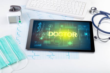 Foto de Tablet PC y material médico con inscripción DOCTOR, concepto de prevención - Imagen libre de derechos