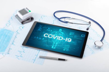 Foto de Tablet PC y herramientas médicas con inscripción COVID-19, concepto de coronavirus - Imagen libre de derechos