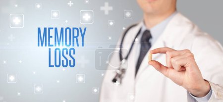 Photo for Close-up of a doctor giving a pill with MEMORY LOSS inscription, medical concept - Royalty Free Image