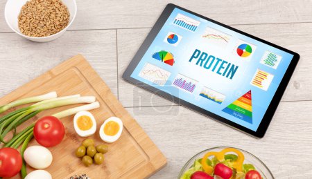Photo for Organic food and tablet pc showing PROTEIN inscription, healthy nutrition composition - Royalty Free Image
