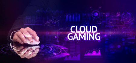 Photo for Hand holding wireless peripheral with CLOUD GAMING inscription, modern technology concept - Royalty Free Image