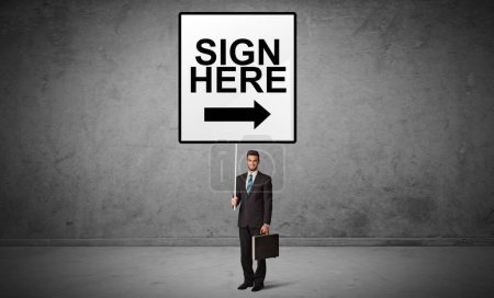 Téléchargez les photos : Homme d'affaires tenant un panneau de signalisation avec inscription SIGN ICI, nouveau concept d'idée - en image libre de droit