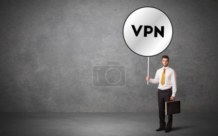 Téléchargez les photos : Un jeune homme d'affaires bloque le panneau de signalisation avec l'abréviation VPN, concept de solution technologique - en image libre de droit