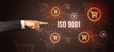 Photo for Close-Up of cropped hand pointing at ISO 9001 inscription, online shopping concept - Royalty Free Image