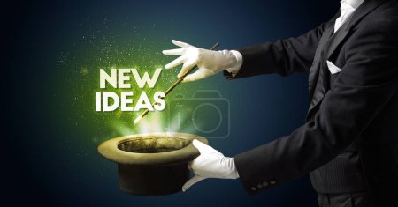 Foto de Illusionist está mostrando truco de magia con la inscripción NEW IDEAS, nuevo concepto de modelo de negocio - Imagen libre de derechos