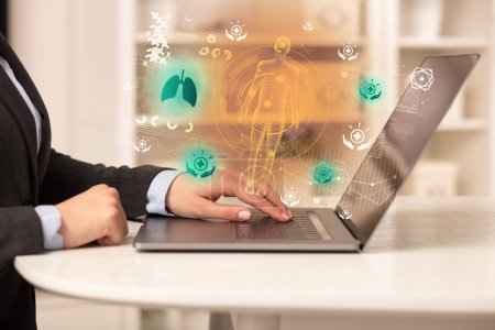 Foto de Médico trabajando en el ordenador portátil con los iconos de los pulmones que salen de ella, concepto de salud - Imagen libre de derechos