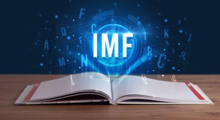 Photo for IMF inscription coming out from an open book, digital technology concept - Royalty Free Image