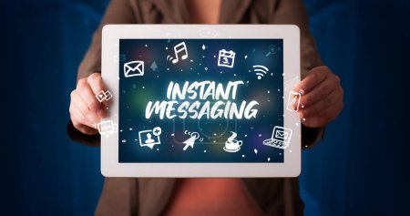 Photo for Young business person working on tablet and shows the inscription: INSTANT MESSAGING - Royalty Free Image