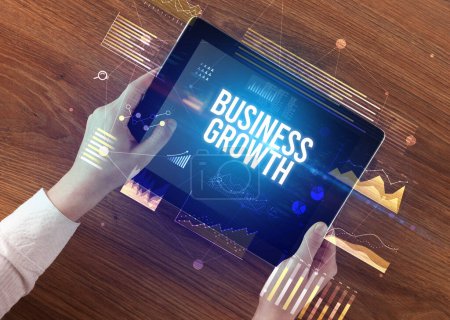 Photo for Close-up of hands holding tablet with BUSINESS GROWTH inscription, modern business concept - Royalty Free Image