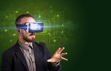 Téléchargez les photos : Homme d'affaires regardant à travers des lunettes de réalité virtuelle avec inscription VISION SOCIALE, concept de réseautage social - en image libre de droit