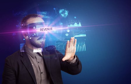 Téléchargez les photos : Homme d'affaires regardant à travers des lunettes de réalité virtuelle avec inscription REVENUE, nouveau concept d'entreprise - en image libre de droit