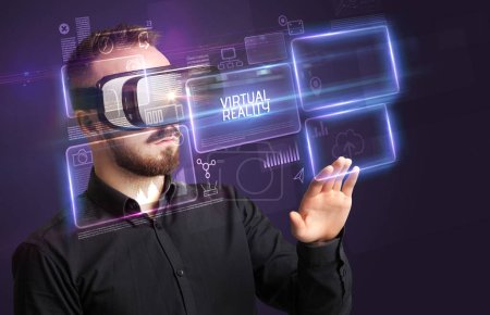 Téléchargez les photos : Homme d'affaires regardant à travers des lunettes de réalité virtuelle avec inscription VIRTUAL REALITY, concept de nouvelle technologie - en image libre de droit