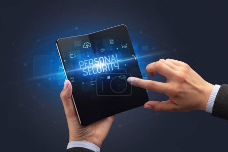 Foto de Empresario con un smartphone plegable con inscripción PERSONAL SECURITY, concepto de seguridad cibernética - Imagen libre de derechos