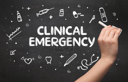 Photo for Hand drawing CLINICAL EMERGENCY inscription with white chalk on blackboard, medical concept - Royalty Free Image