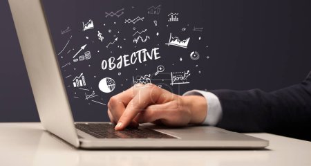 Téléchargez les photos : Homme d'affaires travaillant sur ordinateur portable avec inscription OBJECTIF, concept d'entreprise moderne - en image libre de droit