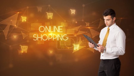 Photo for Businessman with shopping cart icons and ONLINE SHOPPING inscription, online shopping concept - Royalty Free Image