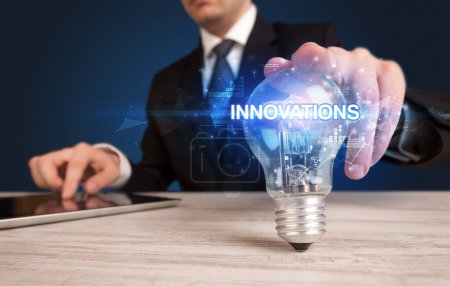 Photo for Businessman holding light bulb with INNOVATIONS inscription, innovative technology concept - Royalty Free Image