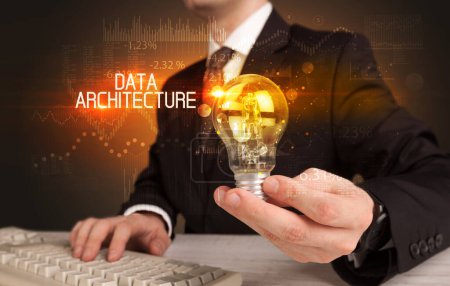Photo for Businessman holding lightbulb with DATA ARCHITECTURE inscription, Business technology concept - Royalty Free Image