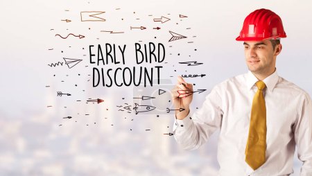 Photo for Handsome businessman with helmet drawing EARLY BIRD DISCOUNT inscription, contruction sale concept - Royalty Free Image