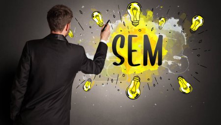 Foto de Hombre de negocios dibujo bombilla de colores con abreviatura SEM, concepto de idea de nueva tecnología - Imagen libre de derechos