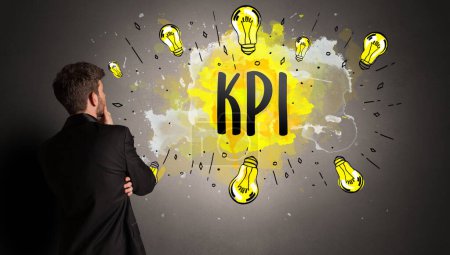 Téléchargez les photos : Homme d'affaires dessin ampoule colorée avec abréviation KPI, concept idée nouvelle technologie - en image libre de droit