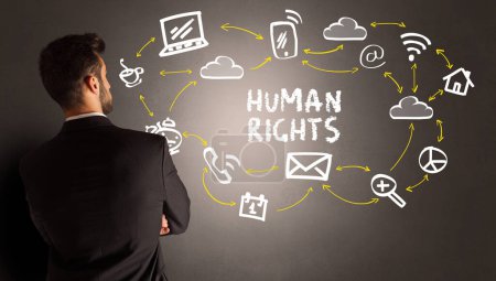 Foto de Hombre de negocios dibujando iconos de redes sociales con inscripción de DERECHOS HUMANOS, nuevo concepto de medios - Imagen libre de derechos