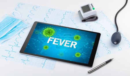 Photo for Close-up view of a tablet pc with FEVER inscription, microbiology concept - Royalty Free Image