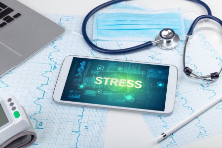 Foto de Tablet PC y material médico con inscripción STRESS, concepto de prevención - Imagen libre de derechos